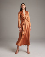 Model wearing a silk Featherlight Wrap Blouse in terracotta, featuring long front sashes.