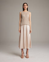 Model wearing a lace knit tank top with a skirt and heels