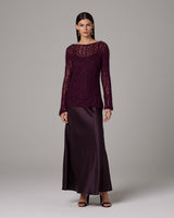Model wearing a burgundy Open Mesh Boatneck Sweater over a satin skirt