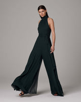 Model wearing a dark green Crinkle Chiffon Palazzo Jumpsuit with a high neck and wide legs