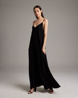 Model wearing a black Parachute Slip Dress, standing in a studio setting