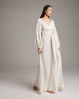 Model wearing a luxurious silk linen peasant blouse with puff sleeves and a defined waistline.