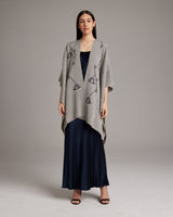 Model wearing a grey Copihue Duster over a navy dress