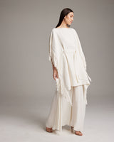 Model wearing a textured cotton fringe kaftan in white, styled with wide-leg pants.