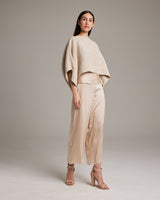 Model wearing a beige Pearl Crop Top with wide sleeves and beige pants
