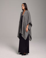 Model wearing a black and ivory Raíz Duster with geometric patterns.
