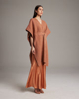 Model wearing a shimmering copper kaftan over a satin slipdress
