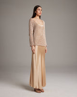 Model wearing a painted loose knit long sweater with a long satin skirt