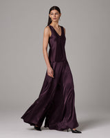 Model wearing silk palazzo pants in dark purple, showcasing the flowing design.
