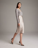 Model wearing a Painted Loose Knit Cropped Sweater with a satin skirt