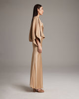 Model wearing a camel bolero over a beige dress