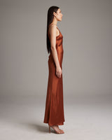Side view of a model wearing a rust-colored Double V Slip Dress in sandwashed silk