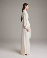 Side view of a model wearing a luxurious silk linen peasant blouse with puff sleeves in ivory.