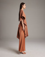 Side view of a woman wearing a shimmering copper kaftan over a slipdress