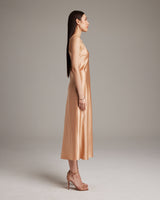 Side view of a model wearing a nude V-neck slip dress