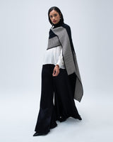 Model wearing a black and white striped edge caftan over a white top and black pants