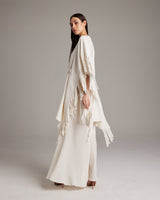 Model wearing a textured cotton fringe kaftan with flowing design and side fringe details.