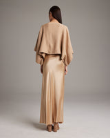 Model wearing a camel bolero over a satin dress from the back