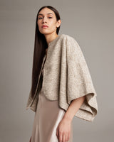 Model wearing a hand-loomed crop bolero in sand color, showcasing its lightweight texture.