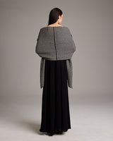 Model wearing a gray Lineas Shawl over a black dress, showcasing the back view.