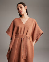 Model wearing a shimmering copper kaftan with a belt