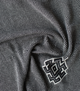 Close-up of Araña Blanket in Charcoal showing intricate weaving and spider symbol