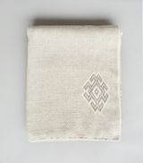 Handwoven ivory Araña Blanket with geometric symbol
