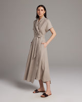 Model wearing a taupe Butterfly Wrap Dress made of linen, featuring short sleeves and a tie waist.