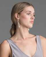 Model wearing chandelier earrings, showcasing their design and length.