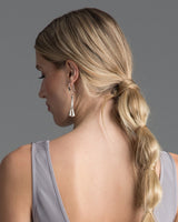 Model wearing chandelier earrings, showcasing their design and length.