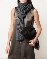Model wearing a grey Chevron scarf, holding a black clutch