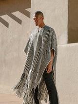 Model wearing a Long Chevron Duster Fringe poncho with fringe details against a neutral background.