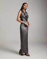 Model wearing a gray convertible halter dress with a cowl neckline and side slit