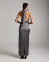 Back view of a model wearing a backless convertible halter dress in silver.