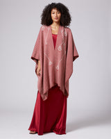 Model wearing a red Copihue Duster with geometric designs