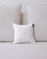 Plain white square pillow on a light-colored couch