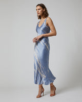 Model wearing a blue tie dye double V slipdress, side view