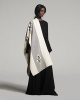 Model wearing the Estrella Shawl, featuring geometric patterns in black and cream.
