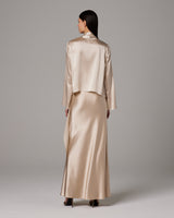 Back view of a model wearing a silk Featherlight Wrap Blouse in a light color