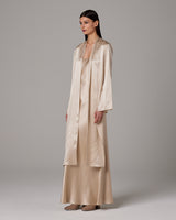 Model wearing a silk Featherlight Wrap Blouse in Bone color, showcasing its drapey design.