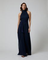 Model wearing a navy Matte Chiffon Palazzo Jumpsuit with a halter neck and removable belt
