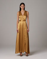Model wearing a gold Frontward Wrap Dress with a deep V-neck and long skirt