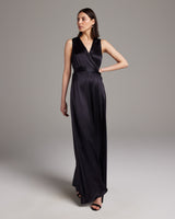 Model wearing a black Frontward Wrap Dress, standing elegantly