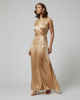 Model wearing a gold Frontward Wrap Dress with a side tie