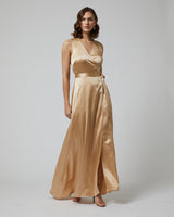 Model wearing a gold Frontward Wrap Dress with a deep V-neck and side slit