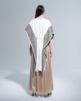Back view of a striped edge caftan in cream and black worn over a long beige dress