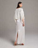 Model wearing a white lace fringe crop top with a long skirt, showing the back view.