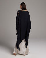 Model wearing a black Lace Fringe Manta over a silk dress, showcasing the fringe detail.
