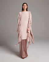 Model wearing a Lace Fringe Manta in rose color, styled with matching pants.