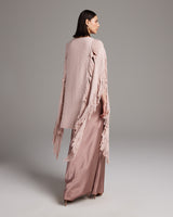 Model wearing a pink Lace Fringe Manta over a long satin dress, showcasing the fringe detail.